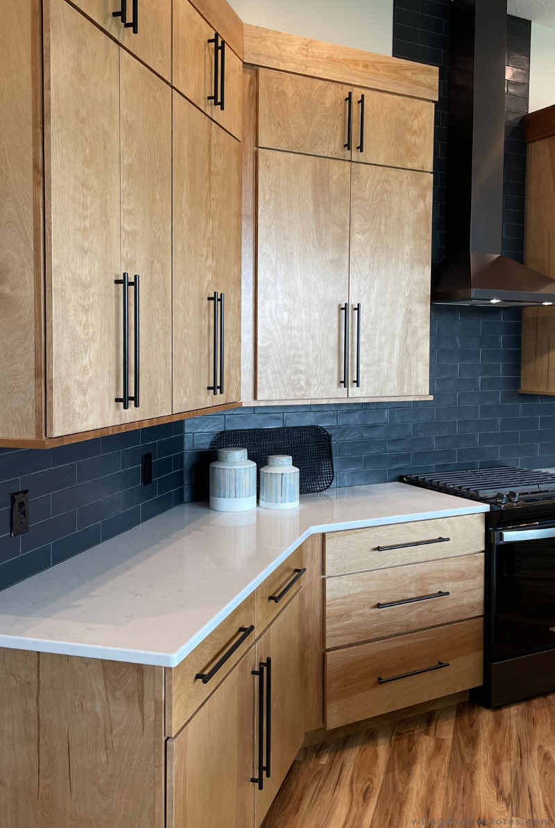 kitchen with tall wall cabinets and black appliances and wall tile