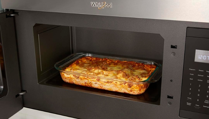 whirlpool microwave hood with door open showing casserole dish inside cavity