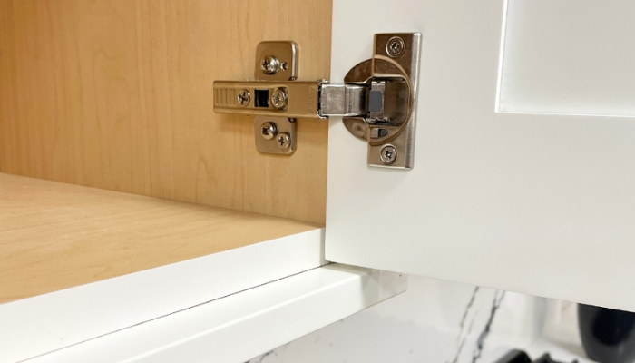 close up image of frameless cabinet shown open with hinge on door