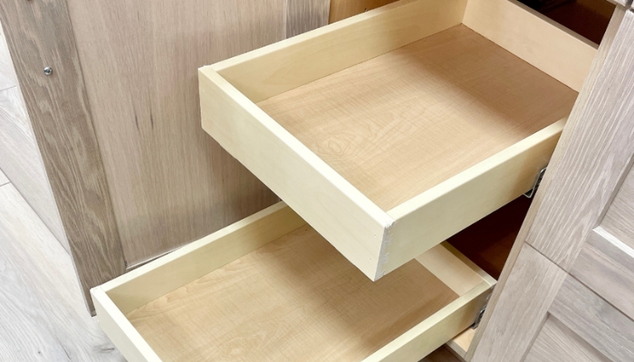 light oak base cabinet with door open showing two empty slide out shelves rolled out