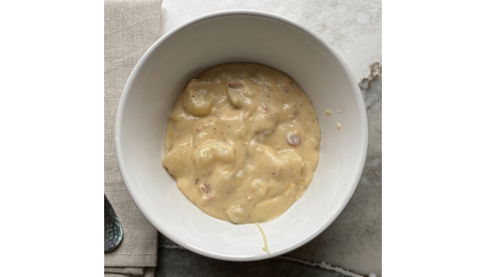Overhead view image of baked potato soup in a bowl.