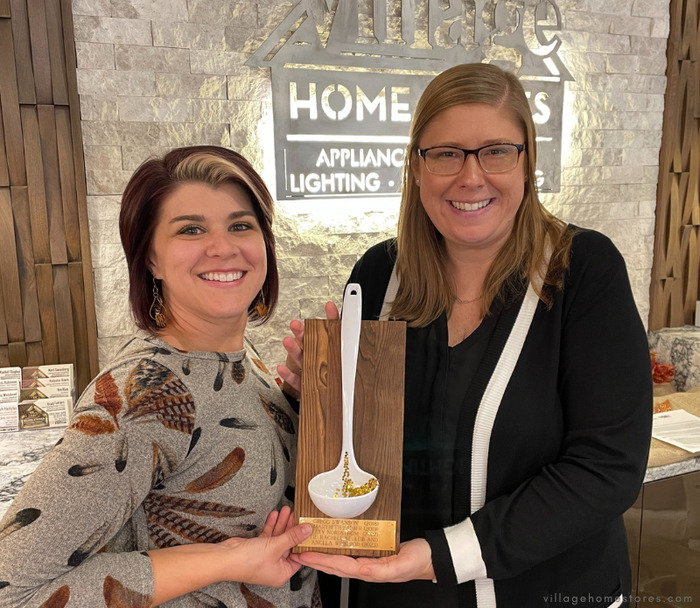 Image of soup cookoff winners Angela and Rachele holding their shared golden ladle plaque 