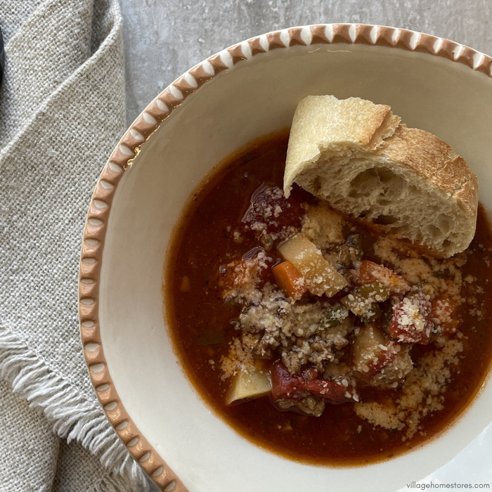 Overhead view image of hamburger soup with slice of crusty bread