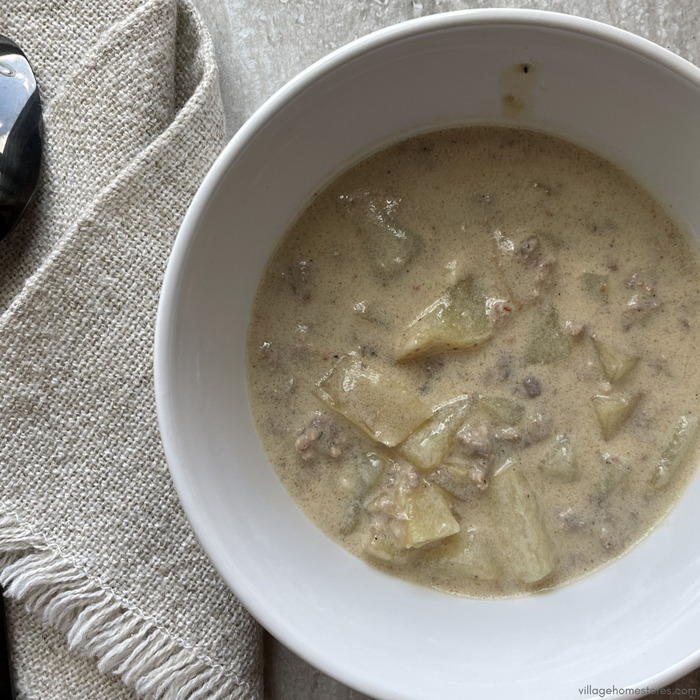 Overhead view image of sausage and potato soup in a bowl.