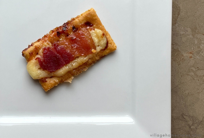 cheese and bacon cracker on white plate