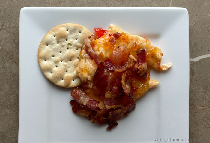pepper jelly cream cheese baked dip on white plate with crackers