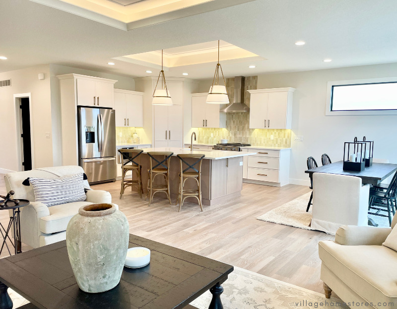 great room kitchen with seating and coffee table in foreground and l-shaped kitchen with oak island in background