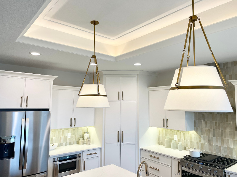 close up image of lighting with linen pendant shades and brass strap details