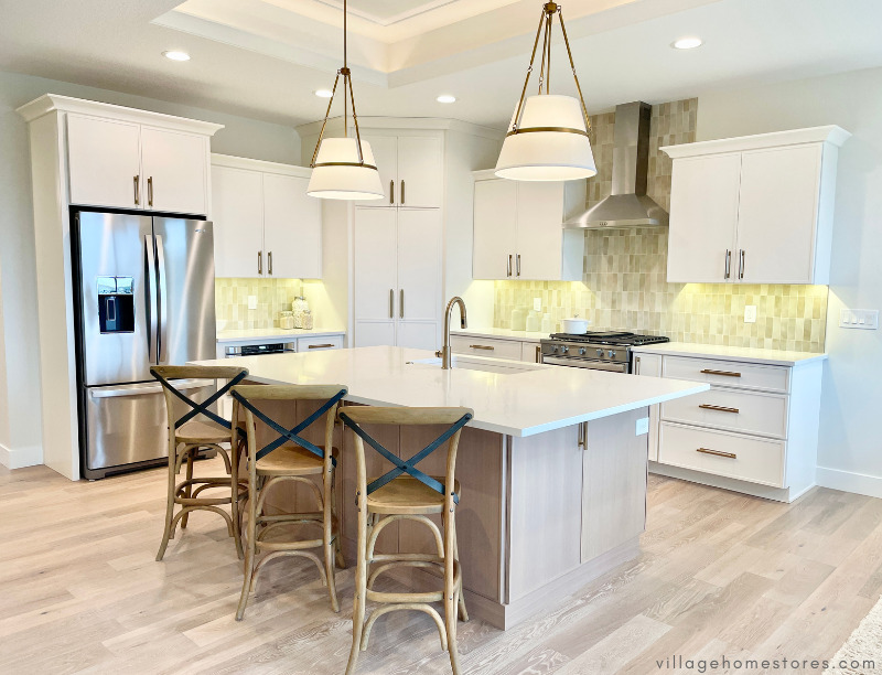 ivory white kitchen with corner pantry and white oak kitchen island with pair of pendant lights above