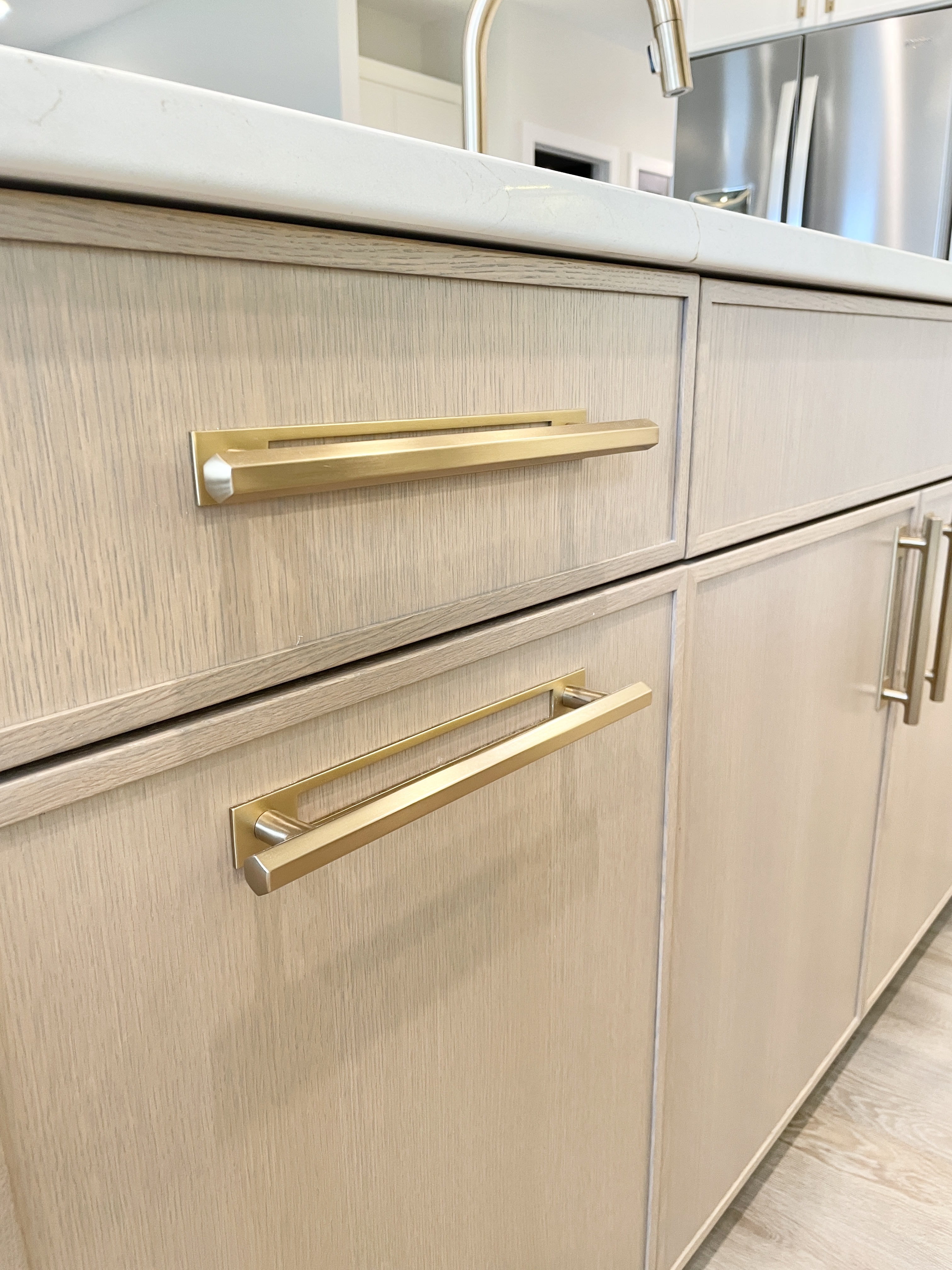 rift cut white oak cabinet doors with satin brass handle hardware and backplates