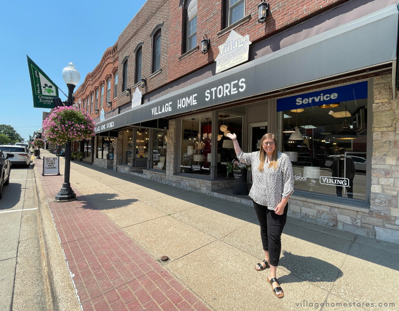 exterior view of village home stores showroom with Rachele outside showing 3 storefronts all connected