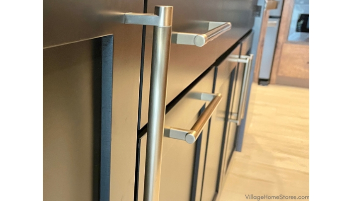 closeup of black painted kitchen cabinets with satin brass emtek hardware