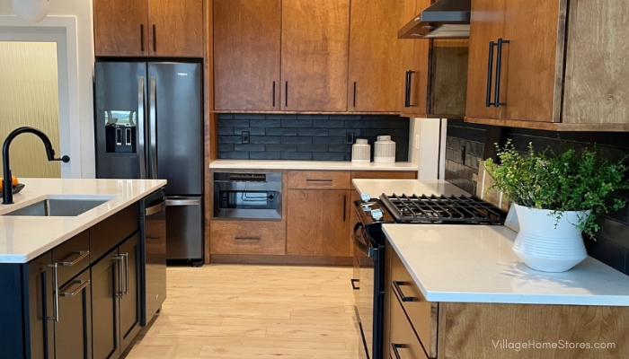 Kitchen design with birch cabinets, black stainless appliances, and black painted kitchen island