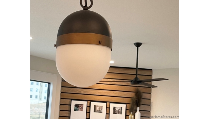capsule shaped pendant lights in matte black and aged brass finishes.