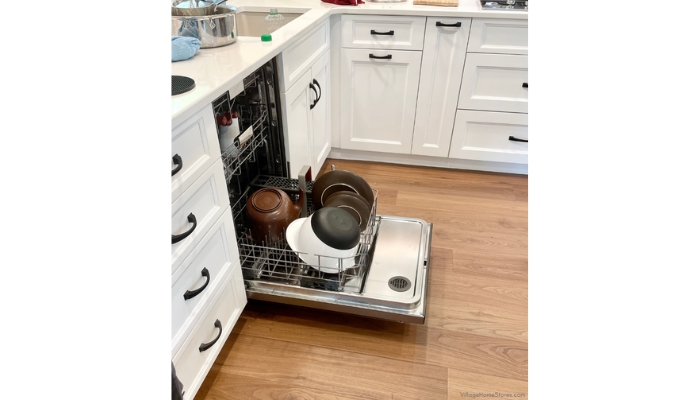 stainless steel kitchen aid dishwasher with three racks inside shown with door open and items loaded