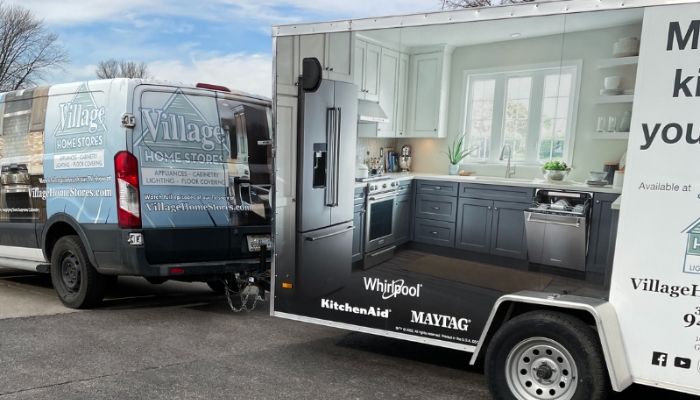 Village Home Stores delivery install van pulling trailer behind it to jobsite of a kitchen remodel in Betendorf, Iowa Quad Cities