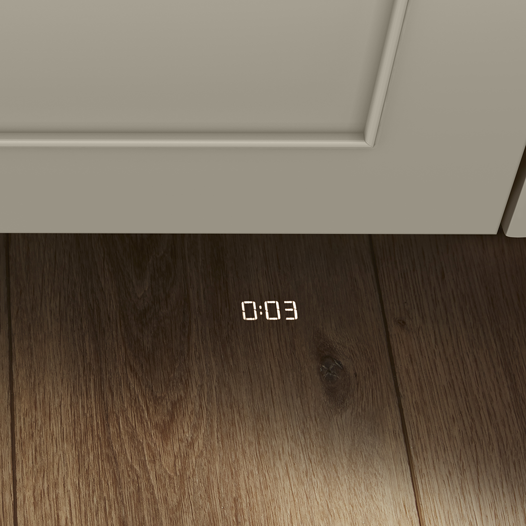 Paneled dishwasher with cycle countdown projecting 0:03 down onto wood floors in toe space