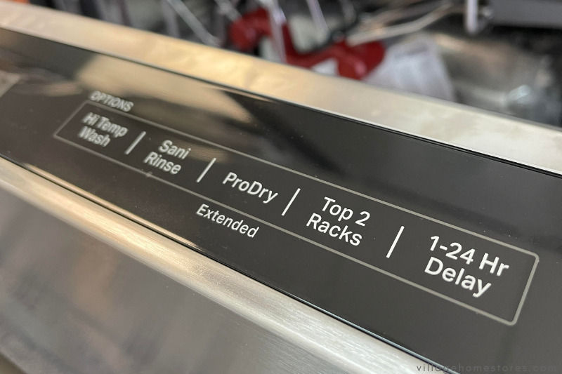Closeup of dishwasher controls with black background and white letters reading pro dry top 2 racks 1-24 hr delay