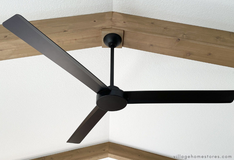 wood beam ceiling with black 3 blade ceiling fan mounted to beam
