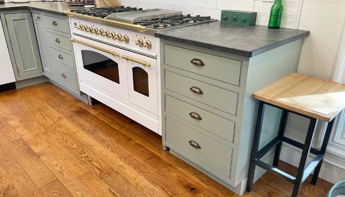 inset green painted kitchen cabinet drawer base with virginia mist granite countertops