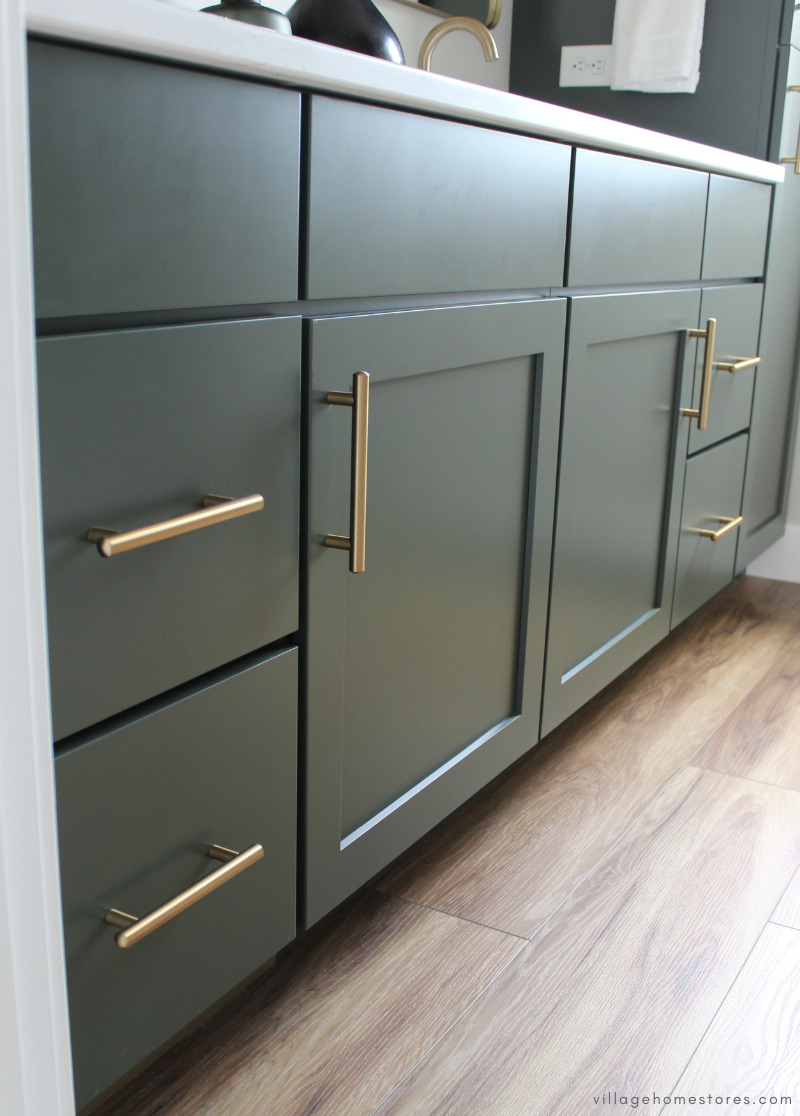 close up of vanity cabinet doors and drawers painted green with brushed gold handle hardware
