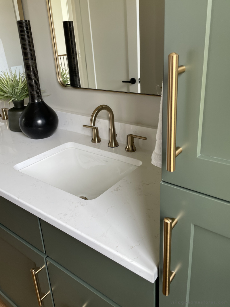 green painted bathroom vanities with white quartz counters and satin bronze handle hardware