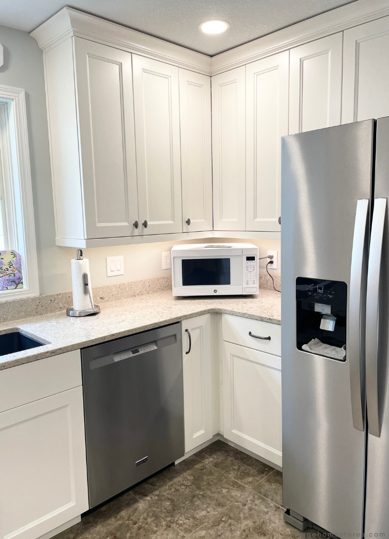 image of kitchen corner with tall white wall cabinets and stainless steel appliances