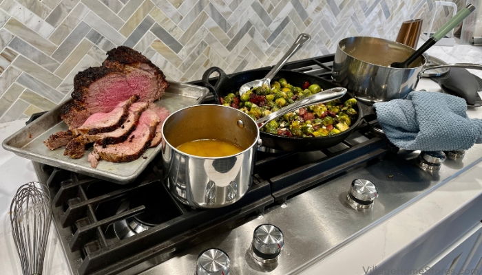 gas cooktop full of food on trays and in pans