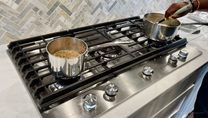 cooktop with 5 burners and full width grates and two pans cooking