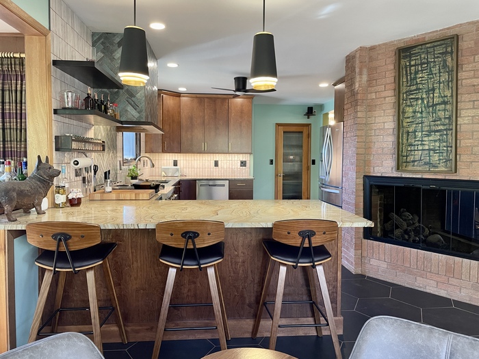 kitchen design with peninsula and bar stool seating with pendant lighting above and brick fireplace in kitchen