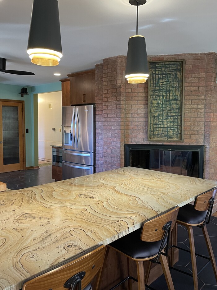 two black pendant lights hang above peninsula countertop