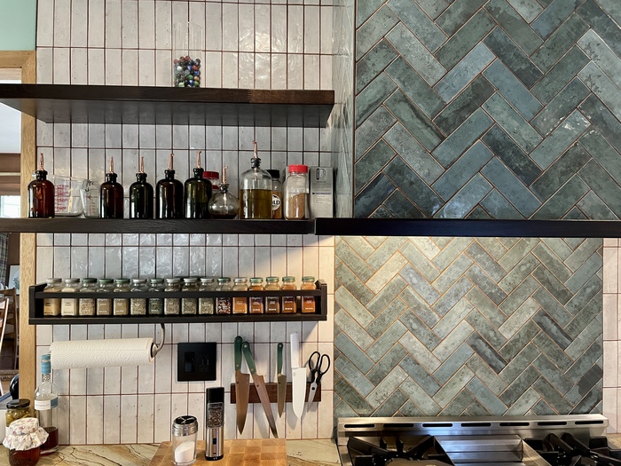 quad cities kitchen with open shelves with spices and green tiled range hood