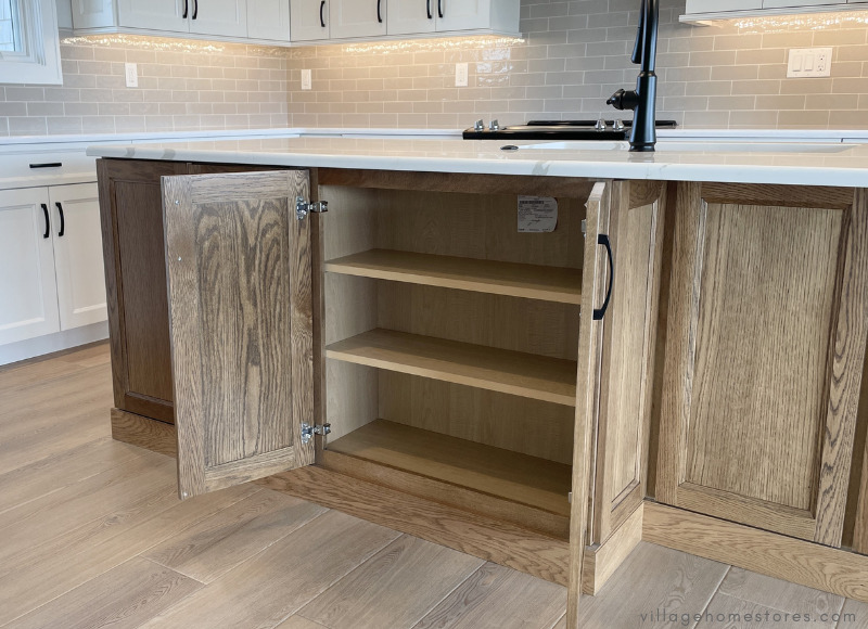 white oak kitchen island with storage on back side shown with doors open and interior shelves displayed