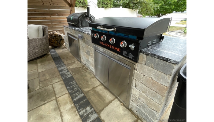 blackstone cooktop and smoker installed in an outdoor kitchen with natural stone countertops from Village Home Stores