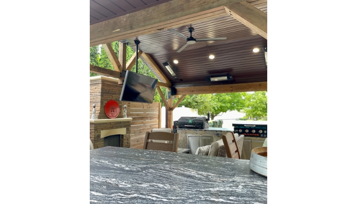 outdoor living room space with black and white granite bar counters and covered patio structure with ceiling mount heaters and outdoor rated ceiling fan in matte black finish