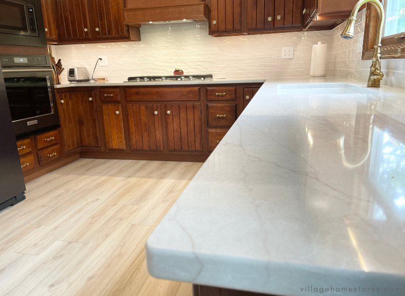 MSI quartz countertops close up image of marble look lumatij design in kitchen with brass faucet
