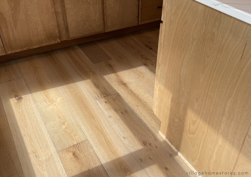 white oak wood flooring with window shadow cast onto floor and side of kitchen island