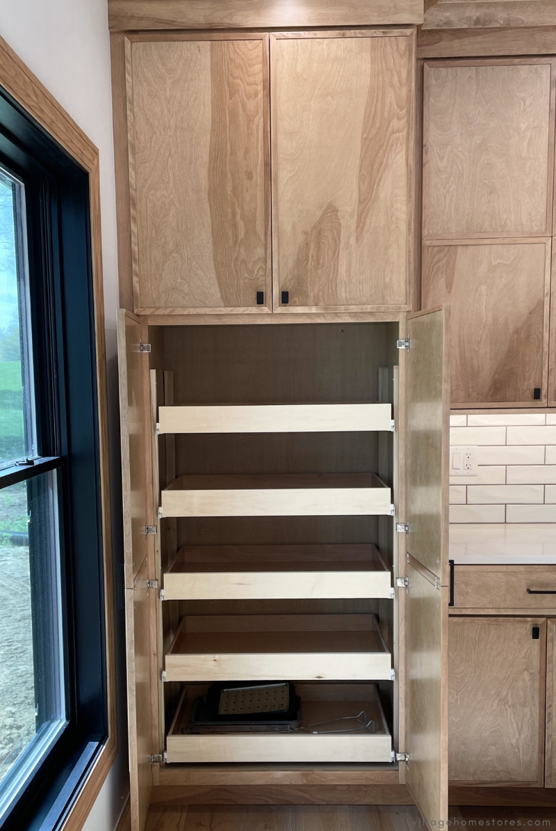 tall pantry cabinet with lower doors open showing slide out shelves