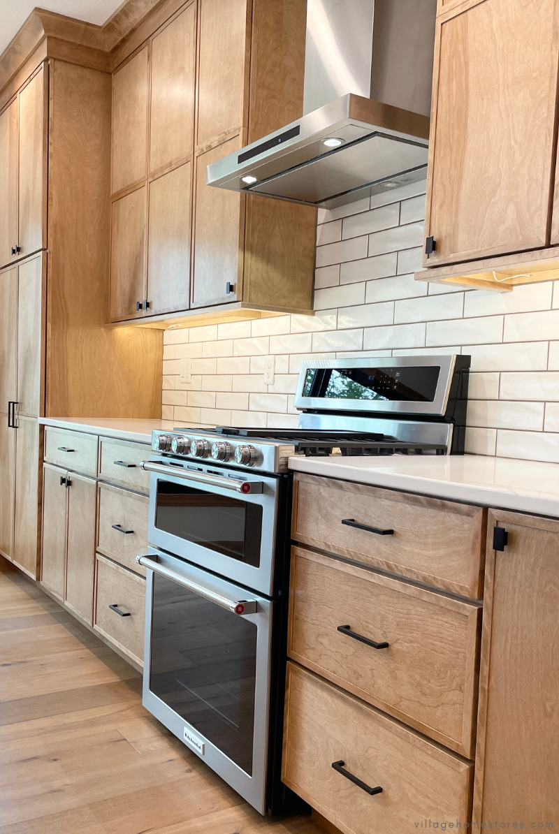 stainless steel double oven range with chimney style hood above