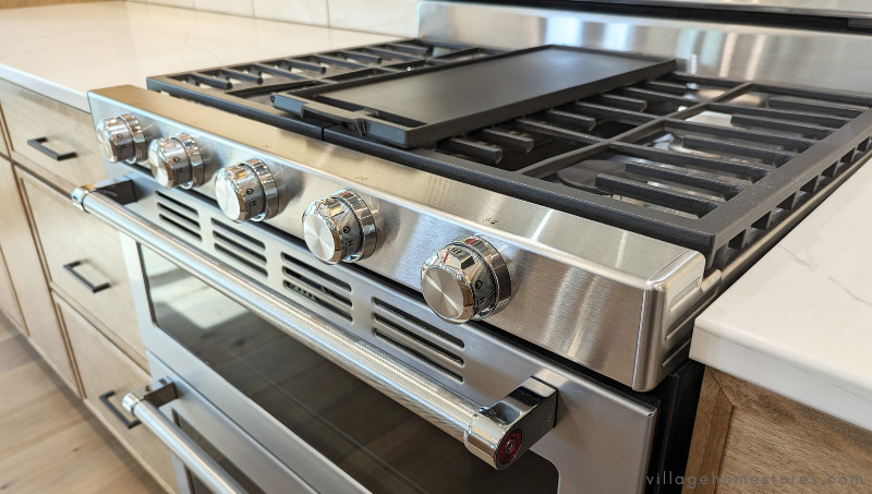 close up of gas cooktop with griddle in place and kitchenaid gas controls and knobs 