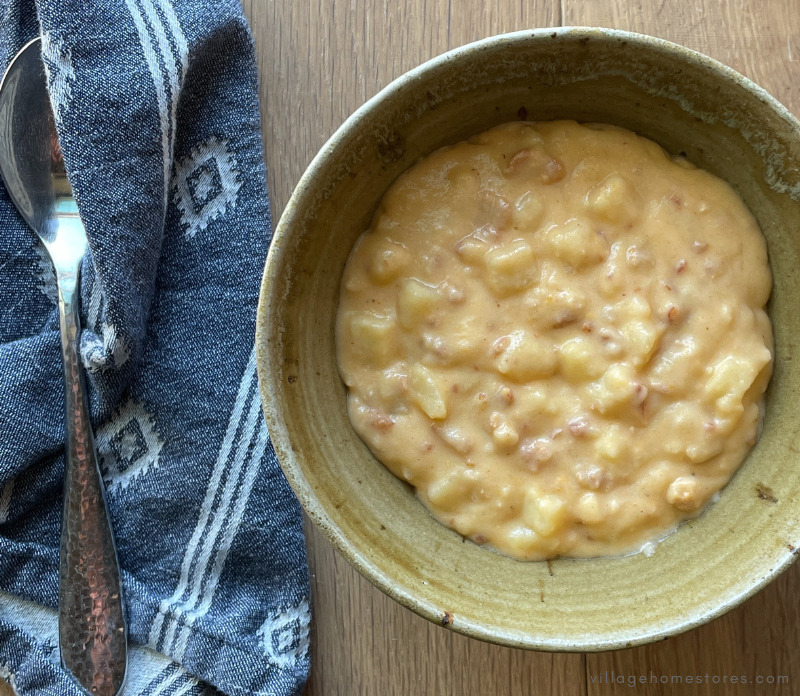 bowl of baked potato soup next to fabric blue napkin
