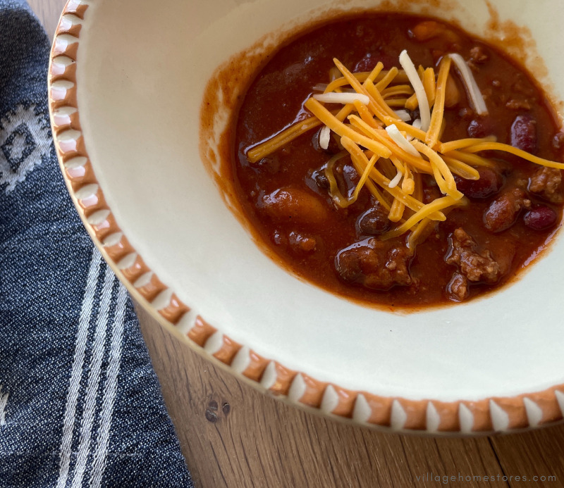 bowl of chili garnished with shredded cheddar cheese