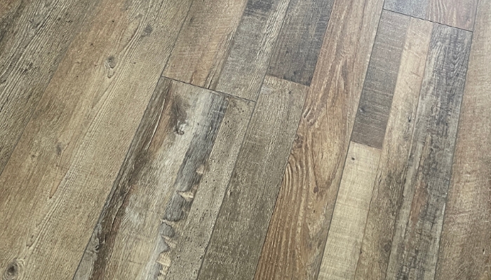 medium tone multi-colored plank flooring from village home stores installed in a Bettendorf Iowa home with colorful stuffed teddy bear laying on it