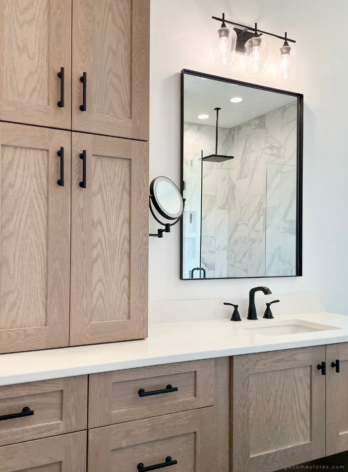 white oak primary bathroom vanity cabinets with white quartz counters and black framed mirror