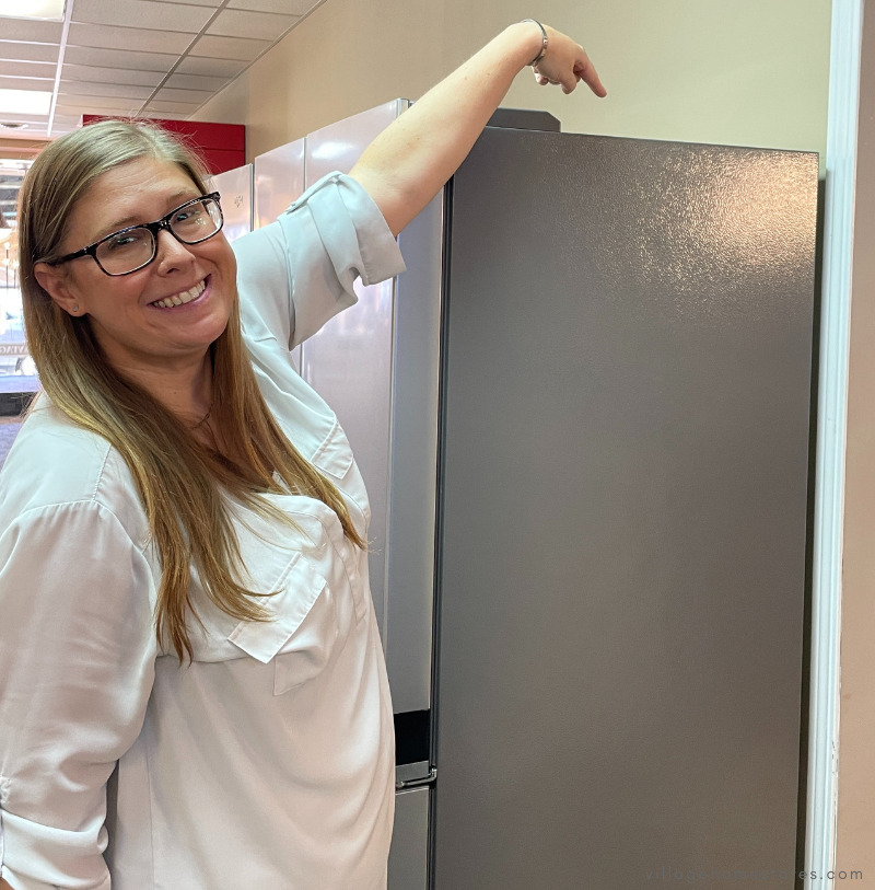 woman in white blouse showing height of refrigerator cabinet