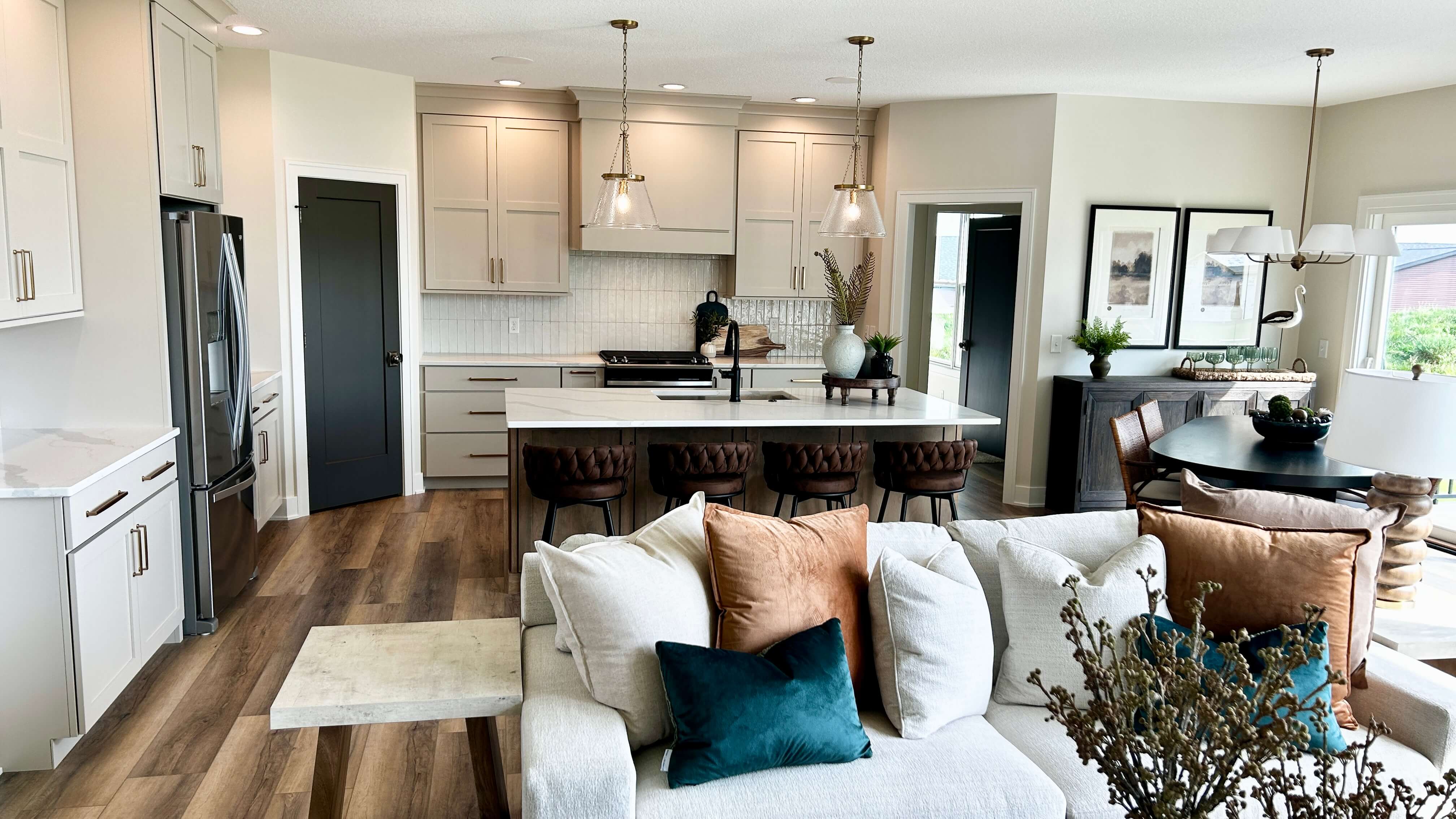 great room kitchen design with accessible beige painted cabinets and velvet sofa cushions in foreground
