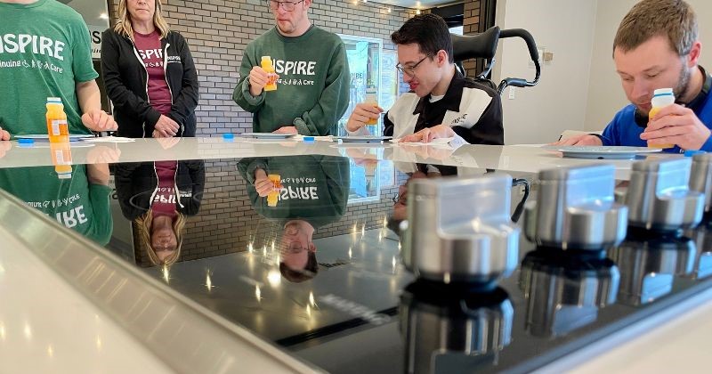 black glass cooktop with reflection of kitchen guests in glass