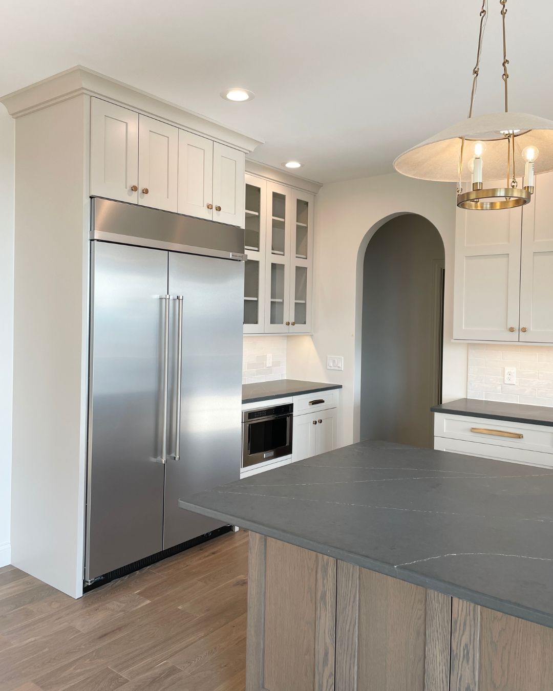 built in side by side refrigerator in white cabinet kitchen with black counters