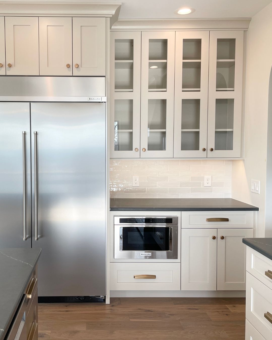 kitchen cabinets with glass doors and stainless undercounter microwave drawer