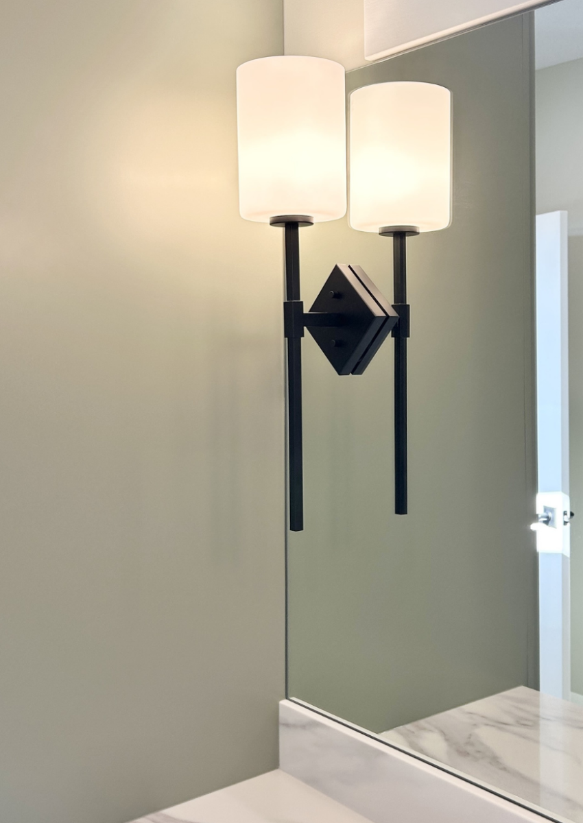 matte black torch style sconce light mounted through mirror